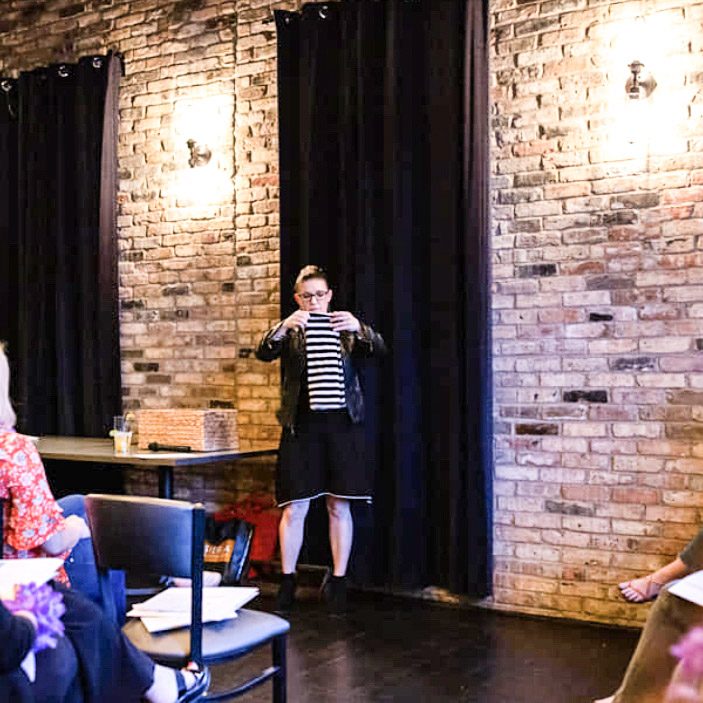 the organized mama speaking at an event to demonstrate how to fold